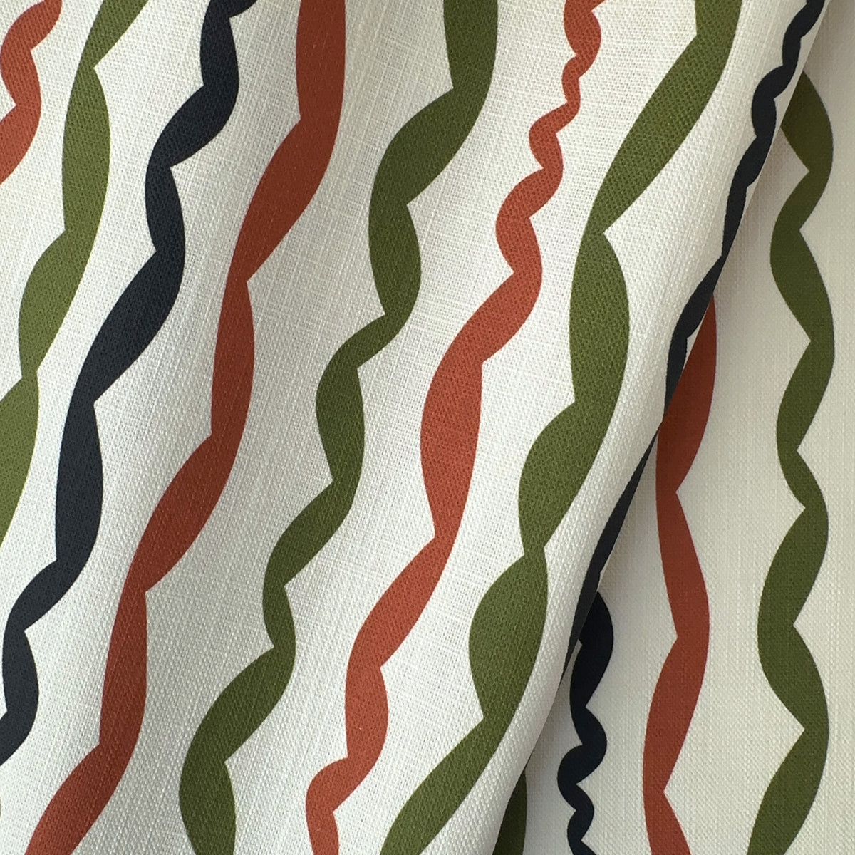 striped linen fabric featuring a contemporary palette of terracotta, green and black on an ivory ground
