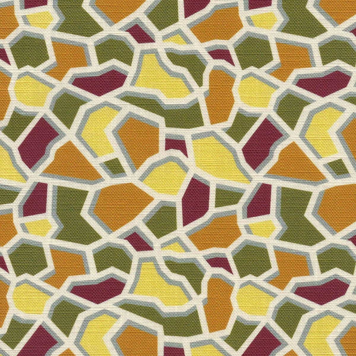 A close-up of a printed linen fabric with an abstract mosaic pattern of irregular polygon shapes in yellow, orange, olive green, burgundy, and cream.